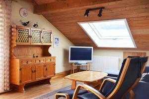 a living room with a television and a table with a chair at Ferienwohnung Wiedenhofer in Regenstauf