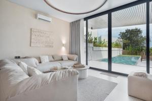 a living room with a white couch and a large window at Balangan Residence in Payangan