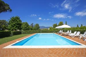 a swimming pool with chairs and an umbrella at Tenuta Santa Colomba - Happy Rentals in Bientina