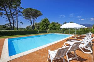 a swimming pool with white chairs and an umbrella at Tenuta Santa Colomba - Happy Rentals in Bientina