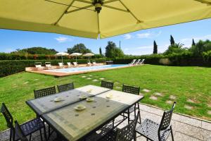a table with chairs and an umbrella in a yard at Tenuta Santa Colomba - Happy Rentals in Bientina +36 photos
