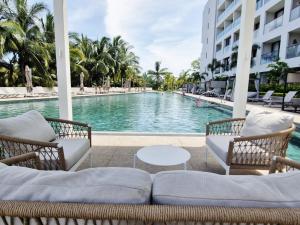 a swimming pool with two chairs and a table at Escapada romántica- decoración sobre pedido in Nuevo Vallarta