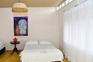 a bedroom with a white bed and a window at HUAIRA Tatacoa in Villavieja