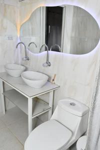 a bathroom with two sinks and a toilet and a mirror at HUAIRA Tatacoa in Villavieja