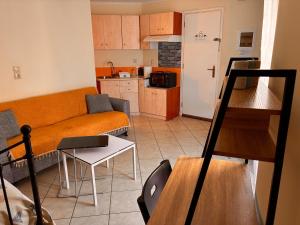 a living room with an orange couch and a kitchen at M A Apartments in Chios