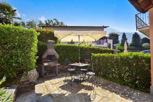 a patio with an umbrella and a table and chairs at Iris in Colico