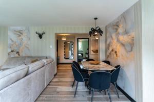 a dining room with a couch and a table and chairs at Gleneagles Village Penthouse in Tullibardine Station