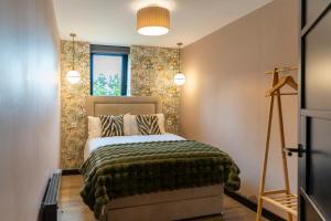 a bedroom with a bed with a green blanket at Gleneagles Village Penthouse in Tullibardine Station