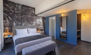 a bedroom with a bed and a wall with a tree mural at Dizengoff Avenue Boutique Hotel - by Echo Hotels in Tel Aviv