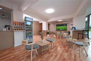 a restaurant with tables and chairs and a tv at Stay C Hotel in Ban Samet