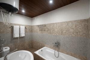 a bathroom with a tub and a toilet and a sink at Hotel The Nature Heaven, Mussoorie - Affordable Luxury Stay in Mussoorie with Mountain View in Mussoorie