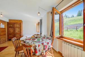 a dining room with a table and a window at Studio Clotes Ski In - Ski Out - Happy Rentals in Sauze dʼOulx