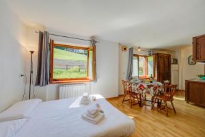 a bedroom with a bed and a table with chairs at Studio Clotes Ski In - Ski Out - Happy Rentals in Sauze dʼOulx +12 photos