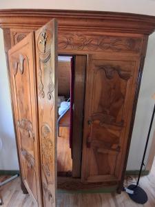 a wooden cabinet with ajar doors in a room at OAK Familly in Saint-Racho