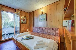 a bedroom with a bed in a room with wooden walls at Appartamento Bareu Mountain View - Happy Rentals in Sauze dʼOulx
