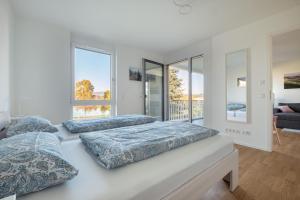 two beds in a white room with windows at Ferienwohnung Badespaß am Schlosssee Salem in Salem