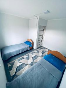 a small room with two beds and a tiled floor at Family nest in Kochkorka