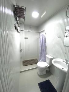 a white bathroom with a toilet and a sink at Family nest in Kochkorka