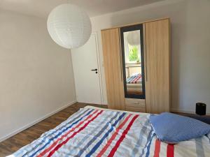 a bedroom with a bed with a red white and blue blanket at Seehaus Brigitte in Owingen