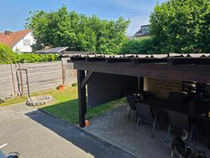 a patio with a table and chairs under a roof at Seehaus Brigitte in Owingen