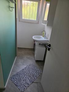 a bathroom with a sink and a window and a rug at Seehaus Brigitte in Owingen +18 photos