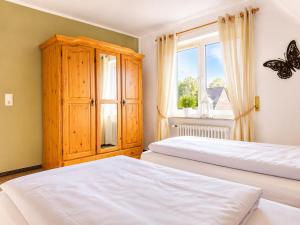 a bedroom with two beds and a window at Dünenlounge Dornumersiel in Dornum