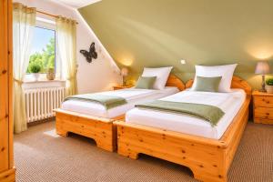 two twin beds in a room with a window at Dünenlounge Dornumersiel in Dornum
