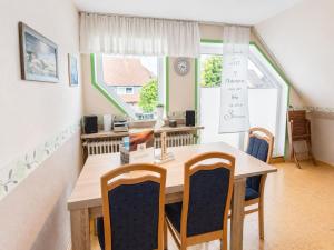 a dining room with a wooden table and chairs at Seehund in Neuharlingersiel
