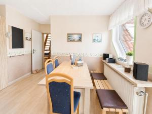 a dining room with a wooden table and chairs at Seehund in Neuharlingersiel