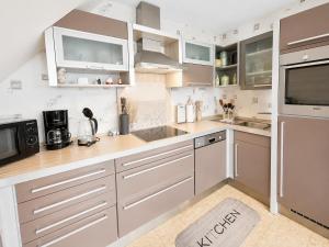 a kitchen with white cabinets and stainless steel appliances at Seehund in Neuharlingersiel