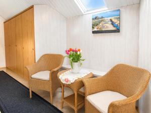 a waiting room with two chairs and a table with flowers at Zum Süderwall in Esens