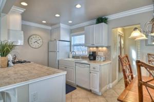 a kitchen with white cabinets and a clock on the wall at San Clemente - Monterey C in San Clemente