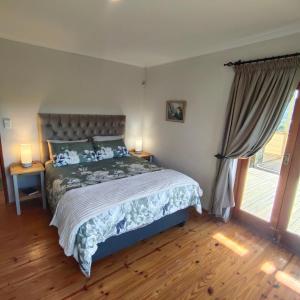 a bedroom with a large bed with two lamps at Zion's Rest in Barrydale