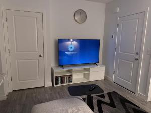 a living room with a flat screen tv on a stand at A very cozy 2-bedroom apartment in Calgary