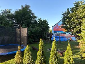 a backyard with a trampoline in front of a building at Domek z basenem in Kodrąb