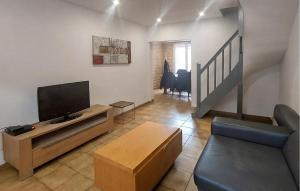 a living room with a flat screen tv and a couch at Jolie Maison Avec Cour in Grand-Fort-Philippe