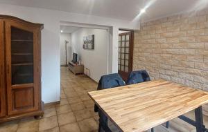 a dining room with a wooden table and blue chairs at Jolie Maison Avec Cour in Grand-Fort-Philippe