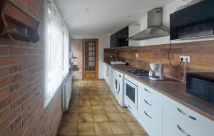 a kitchen with white appliances and a brick wall at Jolie Maison Avec Cour in Grand-Fort-Philippe
