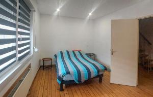 a room with a chair with a striped blanket on it at Jolie Maison Avec Cour in Grand-Fort-Philippe