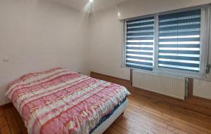 a bedroom with a bed and a large window at Jolie Maison Avec Cour in Grand-Fort-Philippe +9 photos