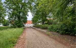 a dirt road with trees and a white building at 2 Bedroom Nice Apartment In Skanderborg in Skanderborg