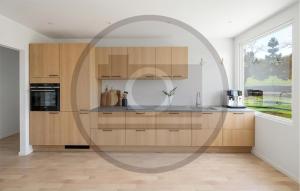 a kitchen with wooden cabinets and a large window at 2 Bedroom Nice Apartment In Skanderborg in Skanderborg
