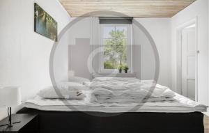 a white bedroom with a large bed with a window at 2 Bedroom Nice Apartment In Skanderborg in Skanderborg +4 photos