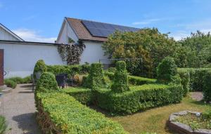 a garden with trimmed hedges and a building at 3 Bedroom Pet Friendly Home In Löderup in Löderup +15 photos