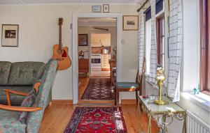 a living room with a couch and a guitar at 3 Bedroom Pet Friendly Home In Löderup in Löderup