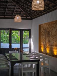a dining room with a table and chairs and windows at Heritage Villa - 05 Bedroom Family Villa in Central Ahangama in Ahangama