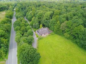 an aerial view of a house in a field next to a road at ManusFaktur Waldcafé und Hotel in Nordhastedt