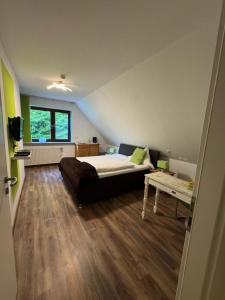 a bedroom with a bed and a table in it at ManusFaktur Waldcafé und Hotel in Nordhastedt