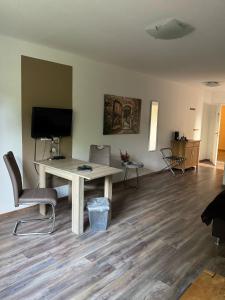 a living room with a table and a television at ManusFaktur Waldcafé und Hotel in Nordhastedt +8 photos