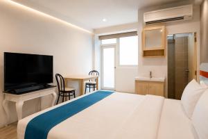 a hotel room with a bed and a television at Suk41 Bangkok Hotel in Bangkok